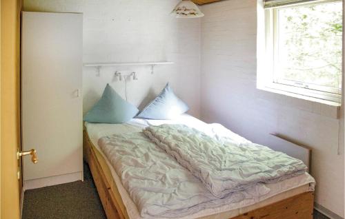 una camera da letto con un letto con cuscini blu di Beautiful Home In rsted With Kitchen a Kare