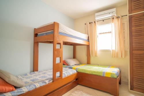 a bedroom with two bunk beds and a window at Casa em condomínio fechado com piscina in Boracéia