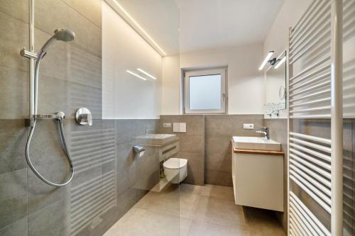 ein Bad mit einer Dusche, einem WC und einem Waschbecken in der Unterkunft Ferienwohnung Lamm 2 in Sankt Valentin auf der Haide