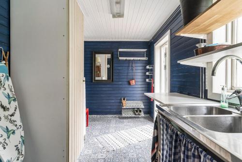 cocina con paredes azules y fregadero en Charming holiday home in Kungsgarden, Gastrikland, en Kungsgården