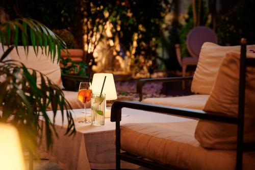 una mesa con una copa de vino junto a un sofá en Hotel Angelo d'Oro en Rovinj