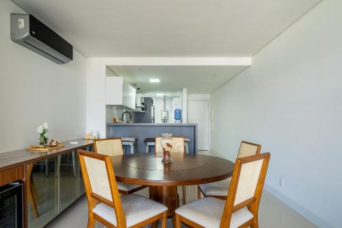 a kitchen and dining room with a wooden table and chairs at Apto charmoso c/ varanda a 150m da praia ABC0403 in Itajaí