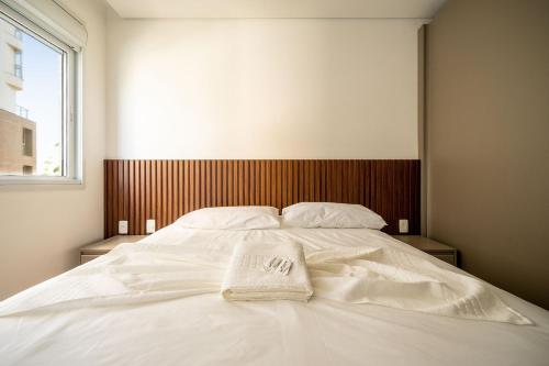a white bed with a towel on top of it at Apto charmoso c/ varanda a 150m da praia ABC0403 in Itajaí