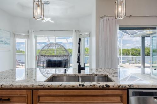 une cuisine avec une cage pour oiseaux dans la fenêtre dans l'établissement Heaven Found! Stunning River Views & Pool - Villa Island Sunset - Roelens Vacations, à Fort Myers