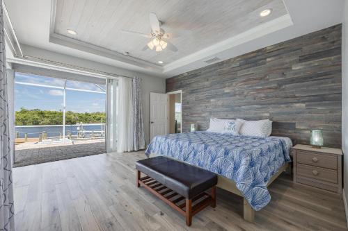 a bedroom with a bed and a stone wall at Heaven Found! Stunning River Views & Pool - Villa Island Sunset - Roelens Vacations in Fort Myers