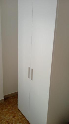 a white cabinet with two doors in a room at Gabrielli Rooms & Apartments - FIERA in Verona