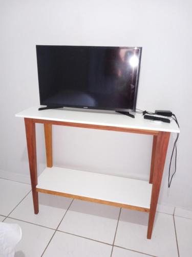 einen TV auf einem Holztisch in der Unterkunft Rosa do deserto in Jerônimo Monteiro