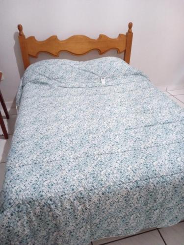 Una cama con una manta azul encima. en Rosa do deserto en Jerônimo Monteiro