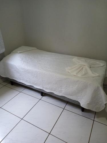 a bed sitting on a tiled floor in a bedroom at Rosa do deserto in Jerônimo Monteiro