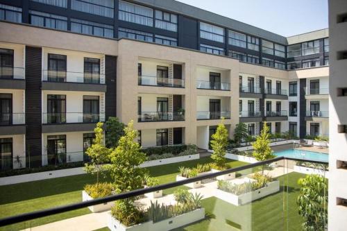 an apartment building with a courtyard with a swimming pool at Cosy 1 Bed Loft @Embassy Gardens in Cantonments