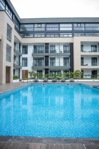 a large swimming pool in front of a building at Cosy 1 Bed Loft @Embassy Gardens in Cantonments