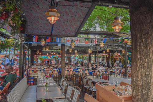 un restaurant avec des tables et des chaises et des personnes qui y sont assises dans l'établissement T1 PRESTIGE PARIS MONTMARTRE, à Paris