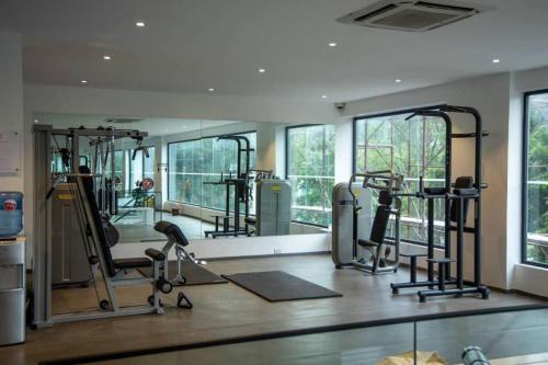 a gym with several treadmills and ellipticals and windows at Cosy 1 Bed Loft @Embassy Gardens in Cantonments