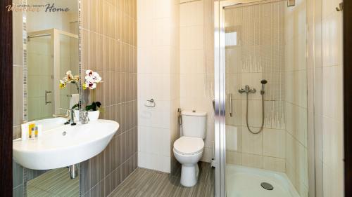 y baño con lavabo, aseo y ducha. en Wonder Home - Apartamenty Czerwony Dworek - duży teren zielony, plac zabaw, miejsce na grilla i staw z możliwością wędkowania, en Mysłakowice