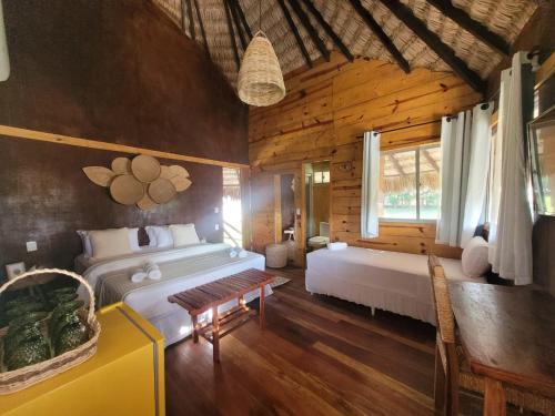 a bedroom with two beds in a log cabin at Mansur Hotelaria de Charme in Luis Correia