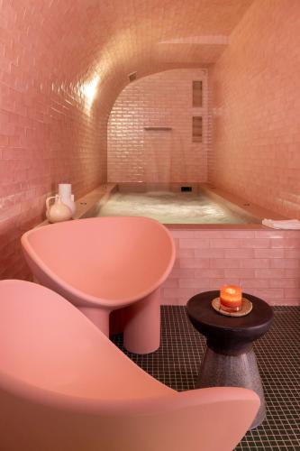 a bathroom with a tub and a table and a sink at Le Petit Oberkampf Hotel & Spa in Paris