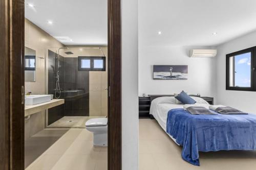 een slaapkamer met een bed en een badkamer met een bad bij Casa Airalba in Tías