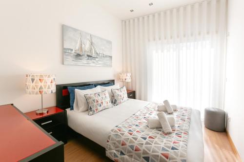ein Schlafzimmer mit einem großen Bett und einem Fenster in der Unterkunft Casa Brilhante - Sunny Delight in Nazaré