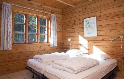 a bedroom with two beds in a log cabin at Stunning Home In Lkken With 8 Bedrooms, Sauna And Indoor Swimming Pool in Lønstrup