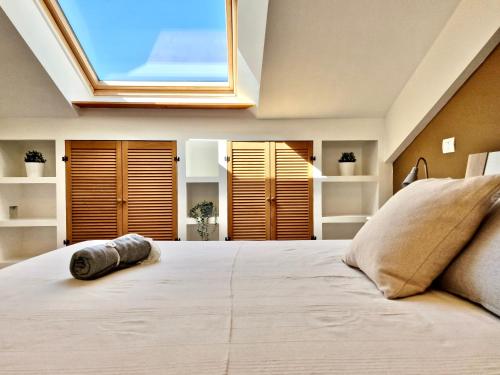 1 dormitorio con 1 cama grande y tragaluz en Casa Elena by TraMonti Apartments en LʼAquila