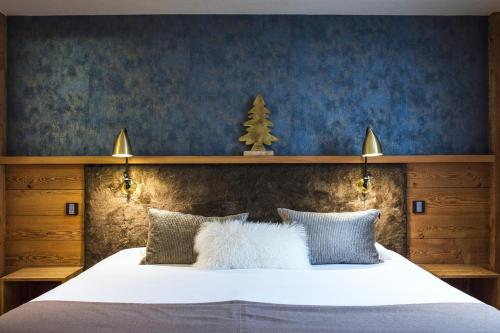 a bedroom with a white bed with a christmas tree above it at Les Cimes in La Clusaz