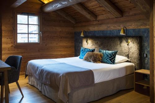 een slaapkamer met een groot bed in een houten kamer bij Les Cimes in La Clusaz