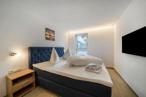 a bedroom with a bed and a tv on a wall at Ferienwohnung Lamm 4 in San Valentino alla Muta