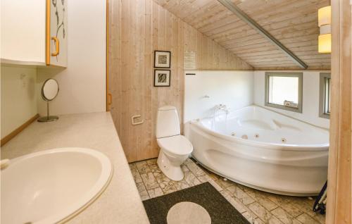 La salle de bains est pourvue d'une baignoire, de toilettes et d'un lavabo. dans l'établissement Beautiful Home In Asperup With 4 Bedrooms, Sauna And Wifi, à Asperup