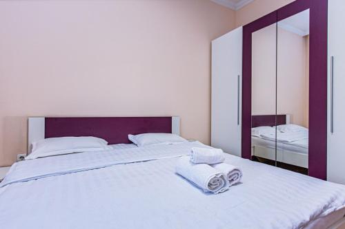 a bedroom with a large white bed with towels on it at Столичка #2 in Almaty