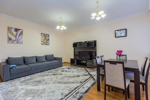 a living room with a couch and a table at Столичка #2 in Almaty
