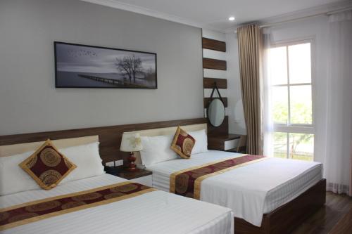 a hotel room with two beds and a window at Huong Duong Sunflower in Ha Long