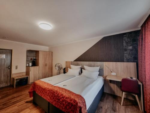 a bedroom with a large bed with a red blanket at Hotel Estricher Hof in Trier