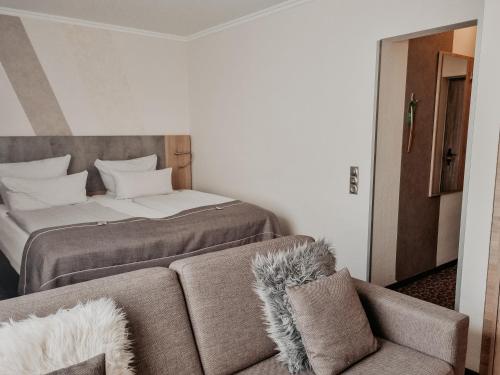 a bedroom with a bed and a couch with at Hotel Estricher Hof in Trier