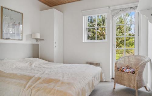 ein weißes Schlafzimmer mit einem Bett und einem Stuhl in der Unterkunft Amazing Home In Gjern With Kitchen in Gjern
