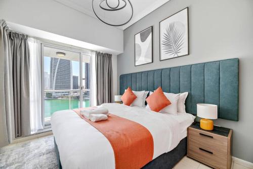 a bedroom with a large bed with a large window at StoneTree - 1BR apartment with Lake View in Dubai