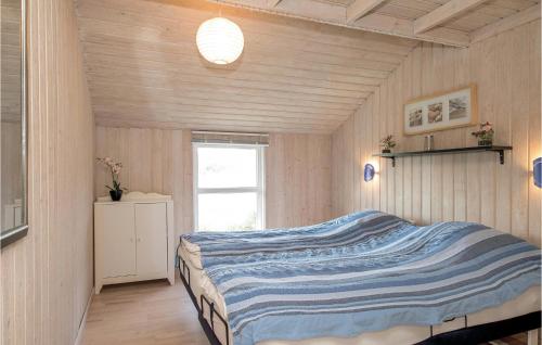 PirupshvarreにあるBeautiful Home In Saltum With 5 Bedrooms, Sauna And Wifiのベッドルーム1室(青と白のストライプの毛布付きのベッド1台付)