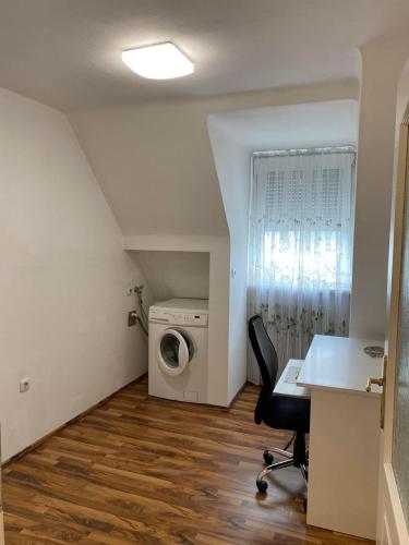 an attic room with a desk and a washing machine at Montel PARK - Linz Danube River in Linz