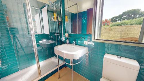a blue tiled bathroom with a sink and a toilet at Villa Buenos - A Murcia Holiday Rentals Property in Santiago de la Ribera
