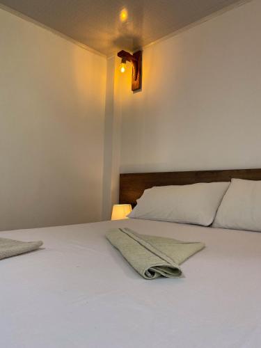 a bedroom with a white bed with two towels on it at Hostería El Sendero - Cocorná in Cocorná