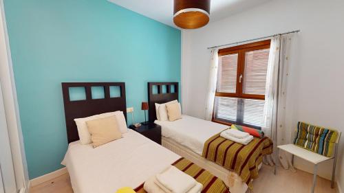 two beds in a room with blue walls and a window at Casa Ortosa C-Murcia Holiday Rentals Property in Baños y Mendigo