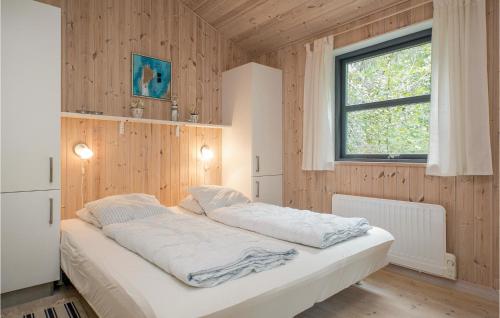 OddeにあるAwesome Home In Hadsund With Kitchenの窓のある木製の壁のドミトリールームのベッド1台分です。