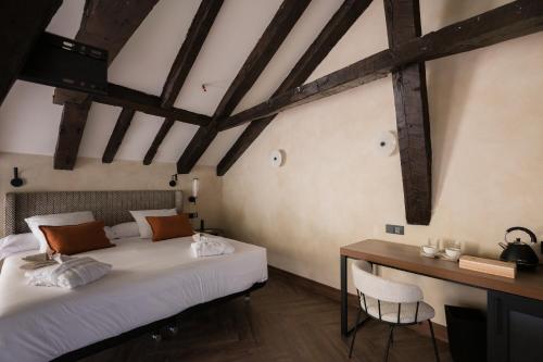 two beds in a room with a desk and a table at Castilla Termal Brihuega in Brihuega