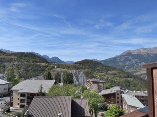 une vue d'une ville avec des montagnes en arrière-plan dans l'établissement Studio au cœur du Sauze, à Enchastrayes