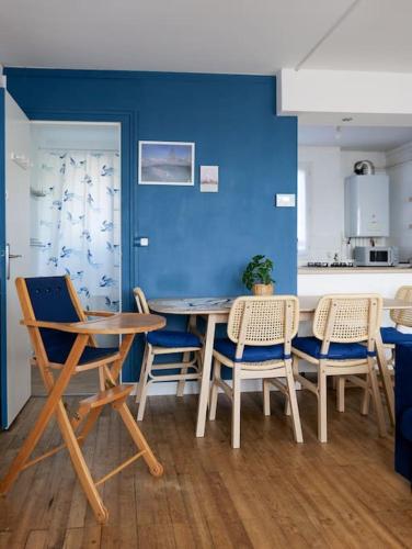 une table et des chaises dans une cuisine avec un mur bleu dans l'établissement Charmant T2 bien placé avec parking, à Nantes