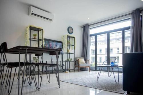 a living room with a table and chairs and a large window at Cosy 1 Bedroom @Embassy Gardens in Cantonments
