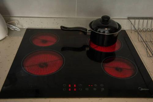 a black stove with a pot on top of it at Cosy 1 Bedroom @Embassy Gardens in Cantonments