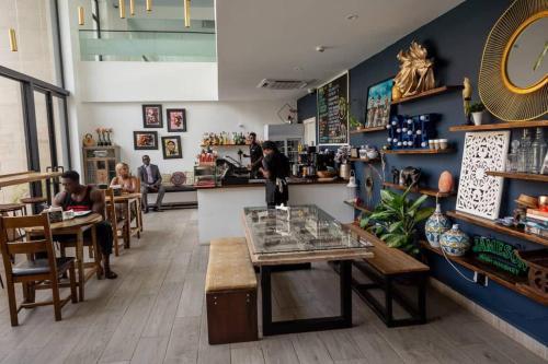 a restaurant with people sitting at tables and a counter at Cosy 1 Bedroom @Embassy Gardens in Cantonments
