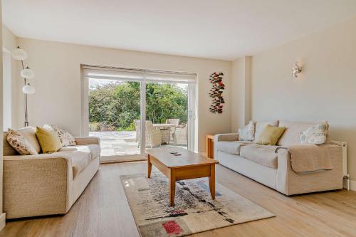 a living room with two couches and a table at Conifers in Lyme Regis
