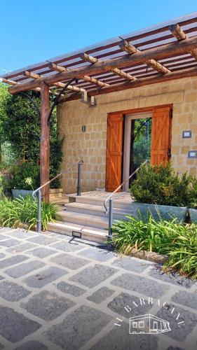 une maison avec une porte en bois et des escaliers à l'avant dans l'établissement Il Barbacane, à Bacoli