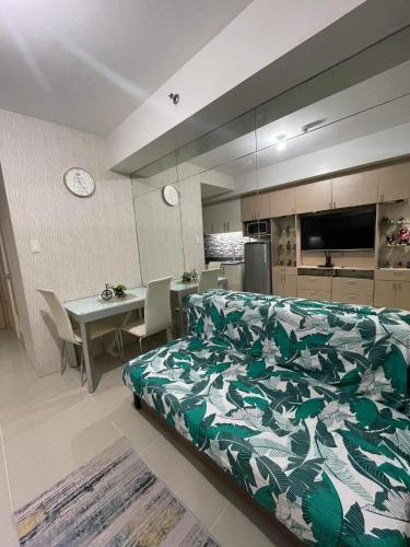 a bedroom with a bed and a table and a kitchen at Sea Residences at Jireh in Pasay